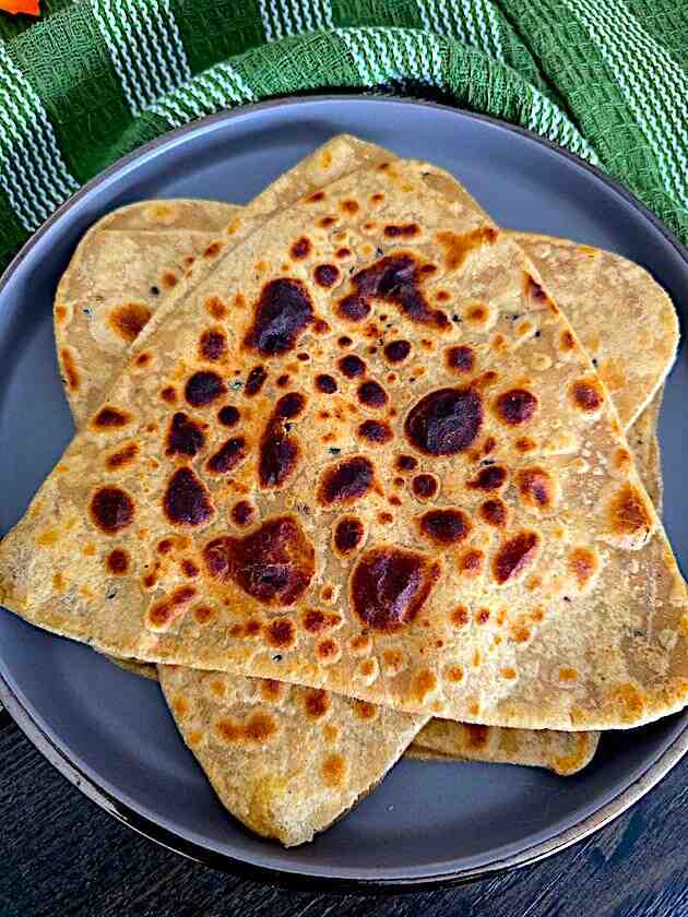 Hot, golden-brown Tawa Triangular Paratha freshly cooked and ready for serving.