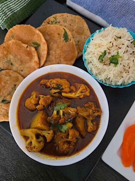 Close-up of Aloo Gobhi curry, showcasing the tender potatoes and cauliflower coated in flavorful spices.