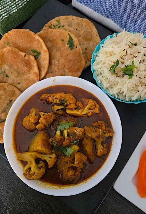 Close-up of Aloo Gobhi curry, showcasing the tender potatoes and cauliflower coated in flavorful spices.