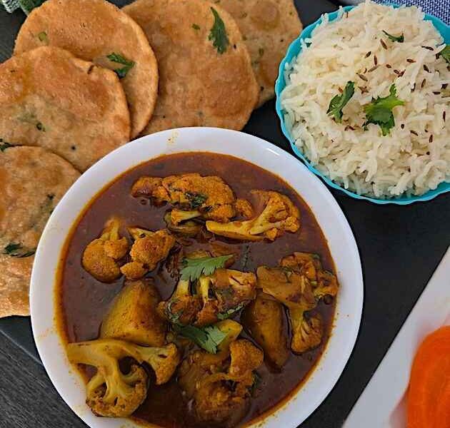 Close-up of Aloo Gobhi curry, showcasing the tender potatoes and cauliflower coated in flavorful spices.
