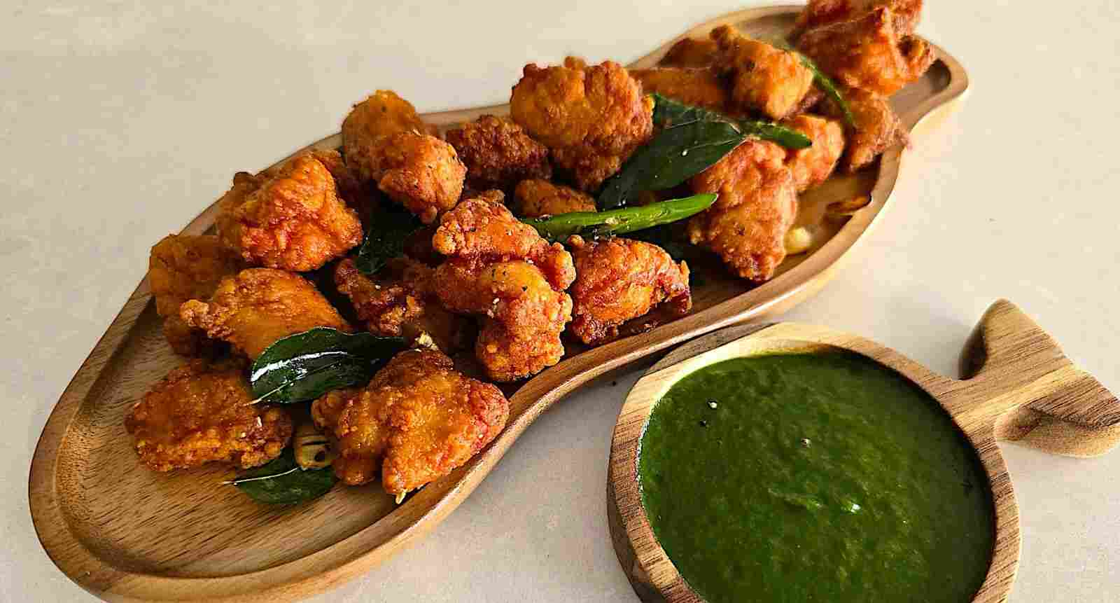 Chicken 65 – Spicy, crispy South Indian fried chicken appetizer garnished with curry leaves.