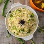 Fluffy Jeera Rice served with a side of flavorful Aloo Curry, garnished with fresh coriander.