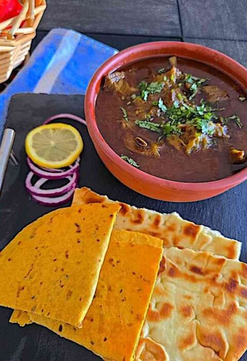 Delicious Mutton Curry served with naan and rice for an authentic Indian meal.