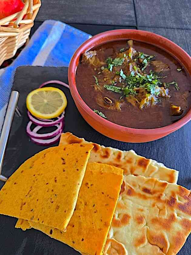 Delicious Mutton Curry served with naan and rice for an authentic Indian meal.